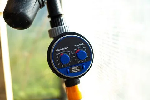 Drip irrigation timer in the greenhouse close-up. Stock Photos
