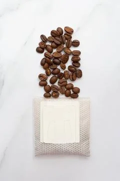 Drip pack and coffee beans on a marble background. Vertical photography. Top Stock Photos