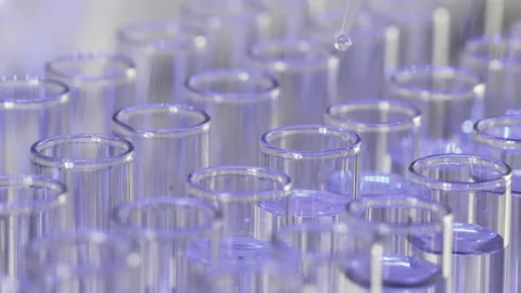 Dripping clear water into test tubes to make experiment Stockbeeldmateriaal 154318902