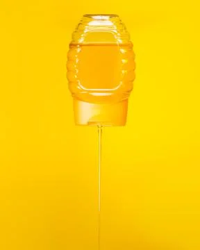 Dripping down honey from a plastic bottle Stock Photos
