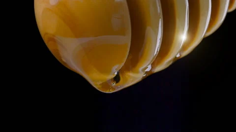 Dripping fresh honey on a black background Stock Footage 97055835