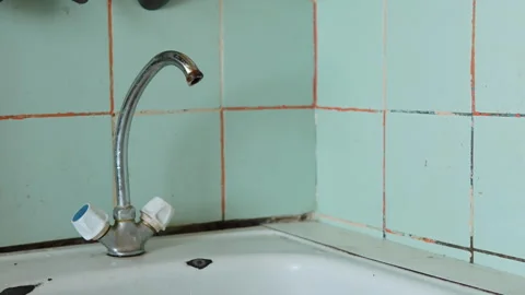 Dripping old tap with rusty spout in authentic kitchen with damaged sink. 스톡 동영상 309980512