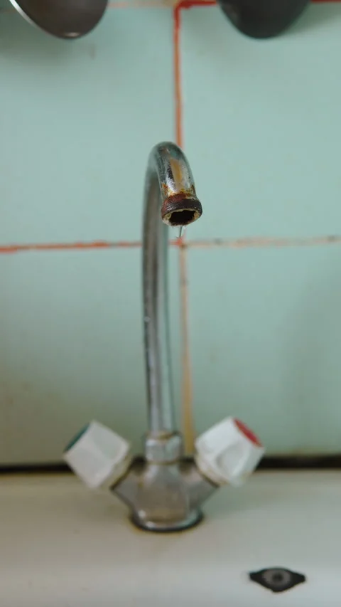 Dripping old tap with rusty spout in kitchen with damaged sink at home. 스톡 동영상 309985215