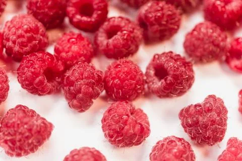 Dripping raspberry on white background. Stock Photos