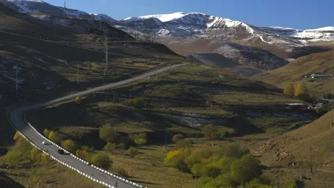 Drive a black car through the mountains. Snow caps of the mountains.  Stock Footage 292880348