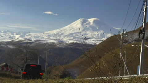 Drive a black car through the mountains. Snow caps of the mountains.  Stock Footage 292880355