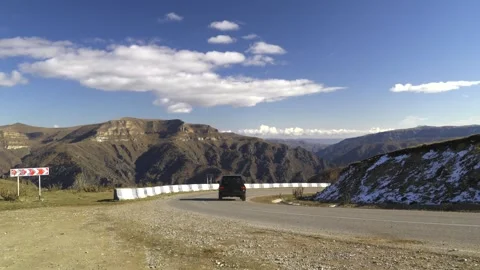Drive a black car through the mountains. Snow caps of the mountains. Stock Footage 292880424