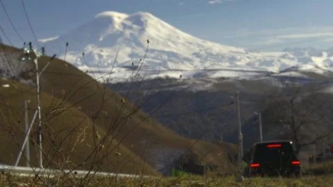 Drive a black car through the mountains. Snow caps of the mountains.  Stock Footage 292880437