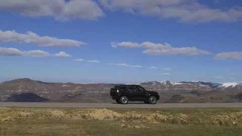 Drive a black car through the mountains. Snow caps of the mountains. Stock Footage 292880440