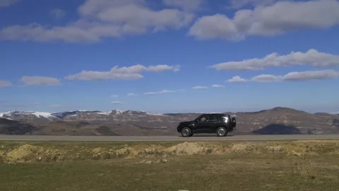 Drive a black car through the mountains. Snow caps of the mountains.  Stock Footage 292880445