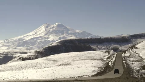 Drive a black car through the mountains. Snow caps of the mountains.  Stock Footage 292880544