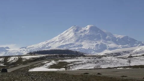 Drive a black car through the mountains. Snow caps of the mountains. Stock Footage 292880545