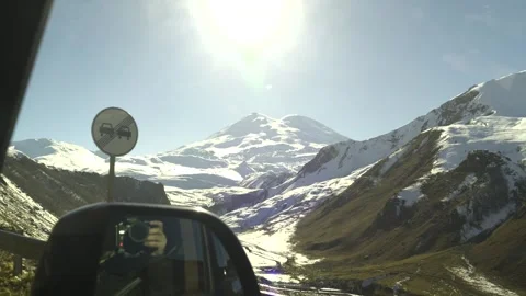 Drive a black car through the mountains. Snow caps of the mountains.  Stock Footage 292880655