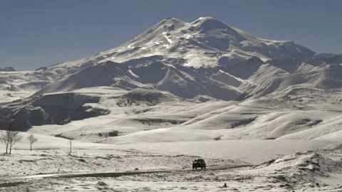 Drive a black car through the mountains. Snow caps of the mountains. Stock Footage 292880684