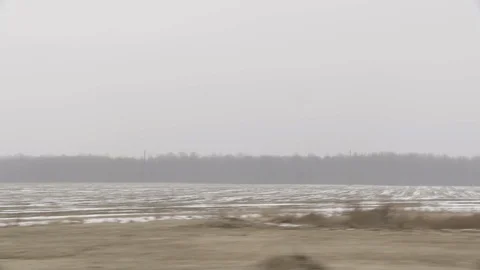 Drive by empty farm fields during winter with some snow Stock Footage 89945151