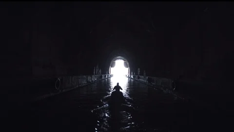 Drive into the light - Jet Ski driving out of dark cave on water Stock Footage 120295637