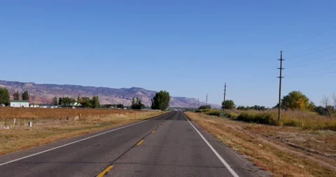 Drive plate-Driving a two lane country road with mountains on left Stock Footage 219440962