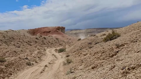 Drive Plate-Forward-Driving privative dirt road thru desert hills Stock Footage 243839772