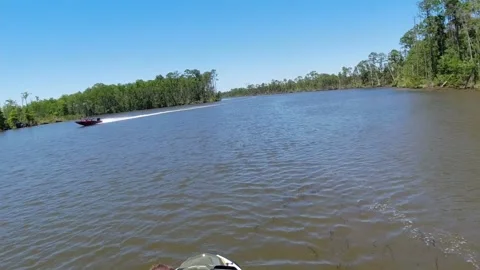 Drive plate fpv of jet ski on a lake meeting a boat and jumping wake Stock Footage 155307632
