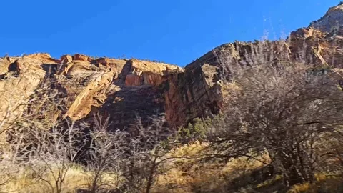 Drive plate-Passing massive cliffs and bare trees Stock Footage 263614200