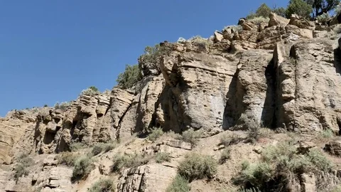 Drive Plate-POV-Driving by Rocky Sandstone Desert Ledges Clear Blue Sky Stock Footage 77136102
