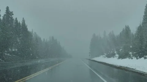 Drive Plate-POV-View forward driving through spring snow Rocky Mtns Stock Footage 76618476