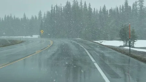 Drive Plate-POV-View forward driving curves spring snow Rocky Mtns Stock Footage 76620358