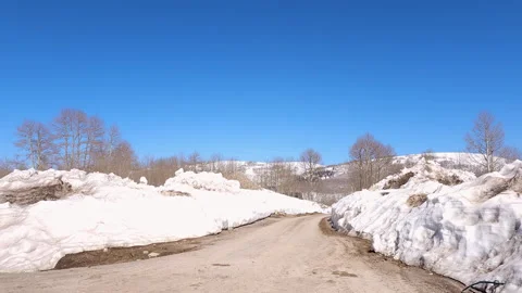 Drive Plate-Side-High snow banks line forest road Aspen forest Blue sky Stock Footage 243847576