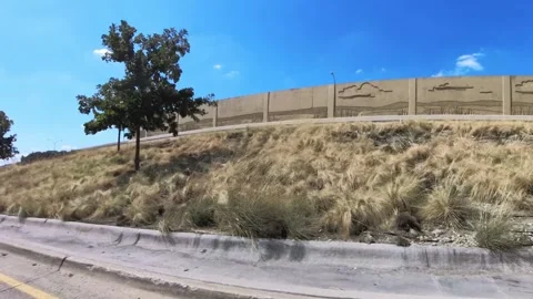 Drive plate, side view, driving on access road, barrier wall blocks freeway 動画素材 252242686