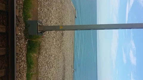 Drive plates. Train movement along sea, railway tracks, bright sky. View from Stock Footage 231761399