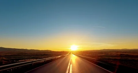 Drive POV at strait road toward sunset Stock Footage