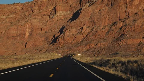 Drive On Road In Desert Background Of A High Wall Of A Rock Monolith At Sunset Stock Footage 120034635