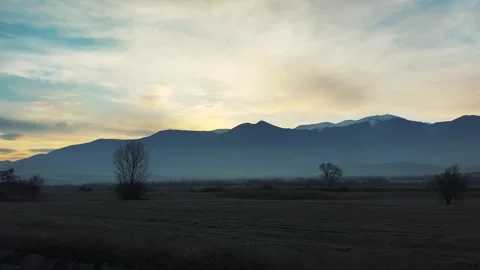 Drive with serene sunset over distant mountains and open fields Stock Footage 344704759