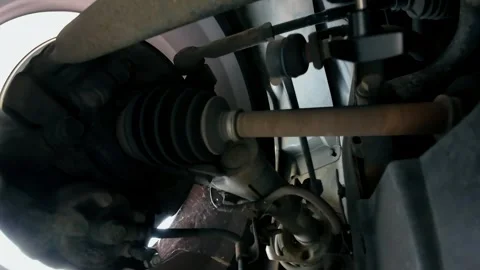Drive shaft and CV joint moving with front suspension while car travels on road Stock Footage 345501131