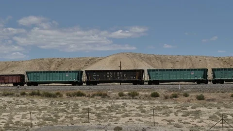DrivePlate-SideView-Desolate Hills Passing Moving Freight Train Stock Footage 77153554