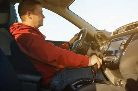 The driver activates the drive option in the automatic transmission. Stock Photos