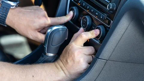 Driver Adjusting Air Conditioning Controls Inside a Car Stock Photos