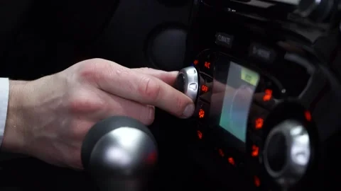 The driver adjusting the volume of a radio inside a car. Stock Footage 169029567