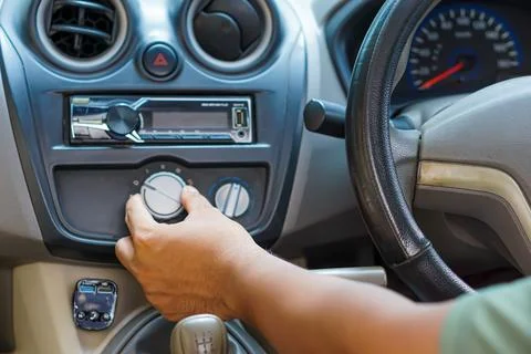 A driver adjusts the air conditioning control while seated in the driver's .. Stock Photos