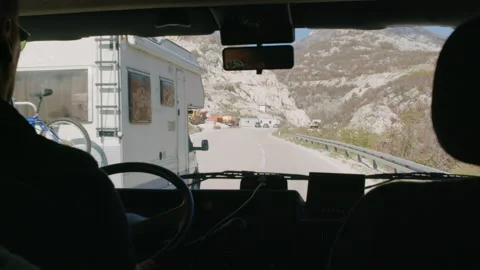 Driver behind wheel of motorhome overlooking campsite in mountains Rbbro. Stock Footage 153040490