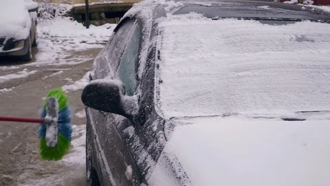 The driver brushes the car from the snow Stock Footage 103473652