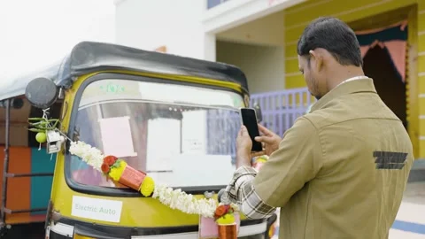 Driver busy taking picture of his new auto Rickshaw before driving to post on 스톡 동영상 169583041
