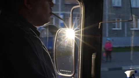 The driver in the cabin of the bus goes on the route smokes while driving Video stock 110827310