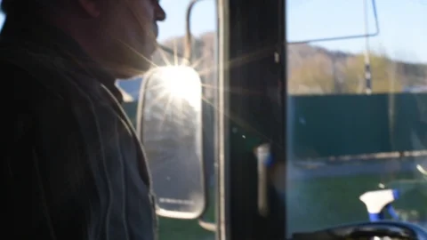 The driver in the cabin of the bus goes on the route smokes while driving Stock Footage 110827320