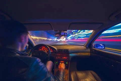 Driver in car moves at fast speed at night. Stock Photos