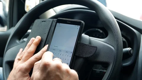 Driver in the car writes a message in messenger by mobile Internet Stock Footage 93778732