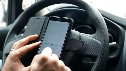 Driver in the car writes a message in the messenger via the mobile Internet Stock Footage 93778953