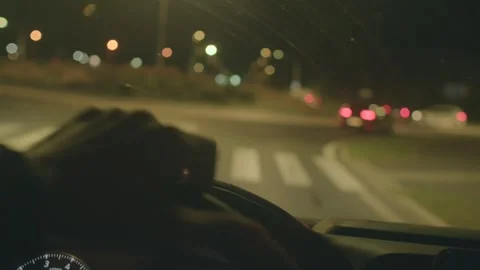 Driver cautiously maneuvering urban streets during nighttime hours Stock Footage 324591565
