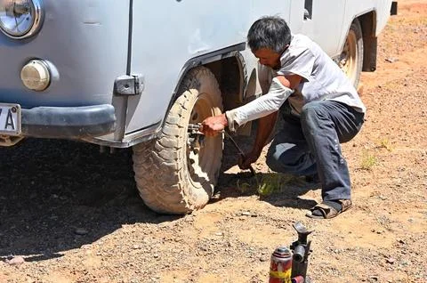 A driver changing flat tire Stock Photos