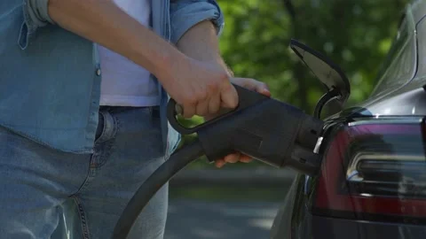 Driver charging electric powered car Stock Footage 135725596
